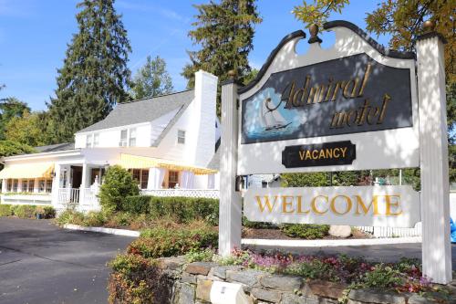 a welcome sign in front of a white house at Admiral Motel in Lake George