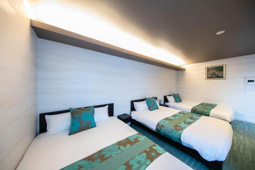 a room with two beds in a room at GRAND BASE Takamatsu in Takamatsu