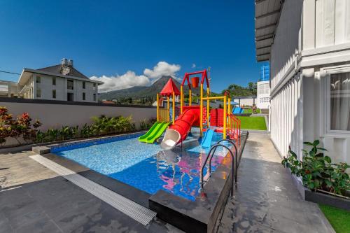 a small pool with a playground in a backyard at Kontena Hotel in Batu
