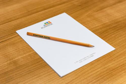 a pencil sitting on top of a piece of paper at Kontena Hotel in Batu