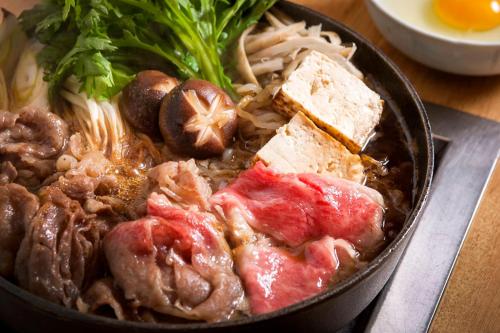 a bowl of food with meat and vegetables on a table at Kitabiwako Hotel Grazie in Nagahama