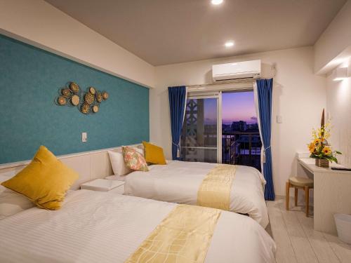 宮古島にあるかりゆしコンドミニアムリゾート宮古島 ふくぎステイズのベッド2台と窓が備わるホテルルームです。