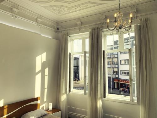 a bedroom with a bed and a large window at Guesthouse Tricana de Aveiro in Aveiro