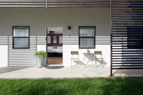 a patio with chairs and a table in a house at Hotel Flora and Fauna in Wimberley