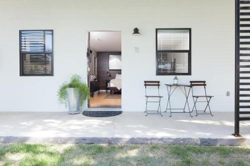a white house with a table and chairs at Hotel Flora and Fauna in Wimberley