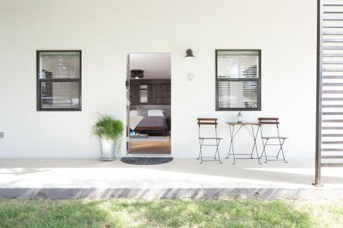 a white house with a table and chairs at Hotel Flora and Fauna in Wimberley