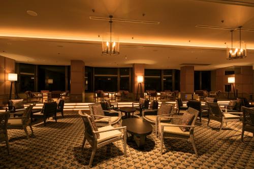 a hotel lobby with chairs and tables and chandeliers at Minakami Hotel Juraku in Minakami