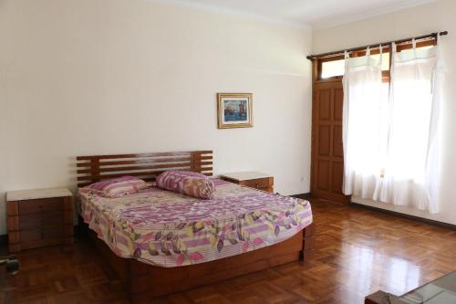 Schlafzimmer mit einem Bett und einem Fenster in der Unterkunft Villa batu malang swimming pool in Batu
