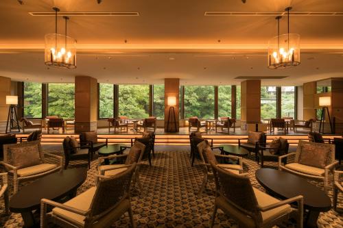 a hotel lobby with tables and chairs and windows at Minakami Hotel Juraku in Minakami