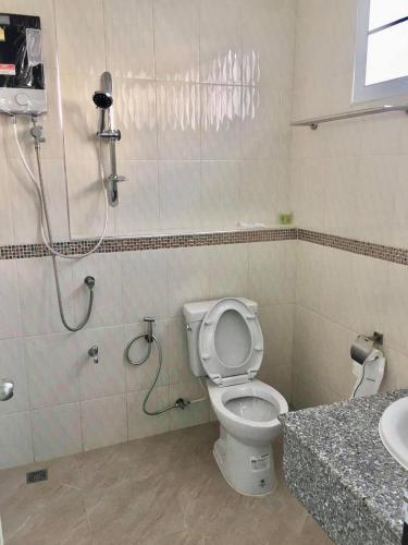 a bathroom with a shower and a toilet and a sink at โรงแรมคูณคีม in Nakhon Phanom