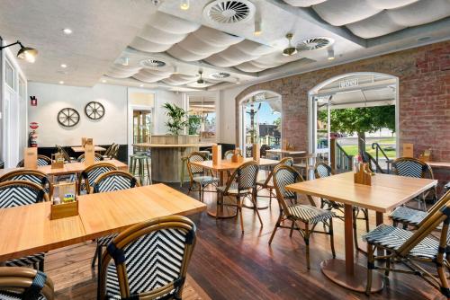 un restaurante con mesas y sillas de madera en Loxton Community Hotel Motel, en Loxton
