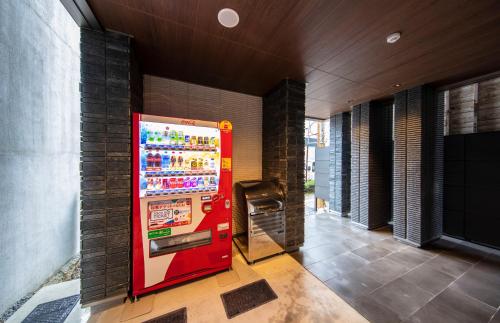 a red vending machine sitting next to a building at GRAND BASE Takamatsu in Takamatsu