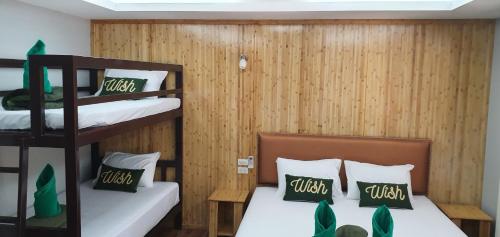 two bunk beds in a room with wooden walls at The Royal Bamboo Lodges - SHA Certified in Khao Sok