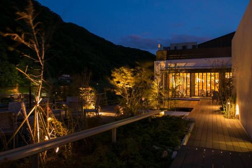 un bâtiment avec des lumières devant lui la nuit dans l'établissement Minakami Hotel Juraku, à Minakami