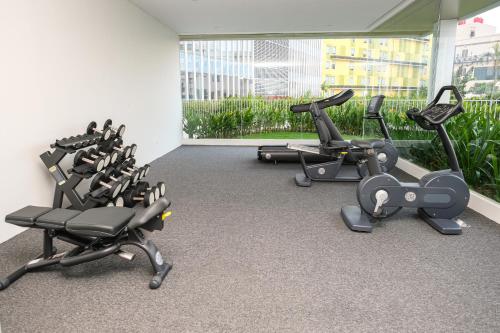 a gym with a row of exercise bikes at LOVINA 6-12 at Harbour Bay Residences in Nagoya