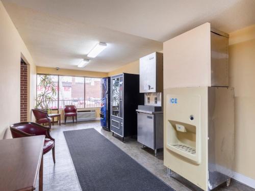 a kitchen with a refrigerator and a table and chairs at Mansion View Inn & Suites in Springfield