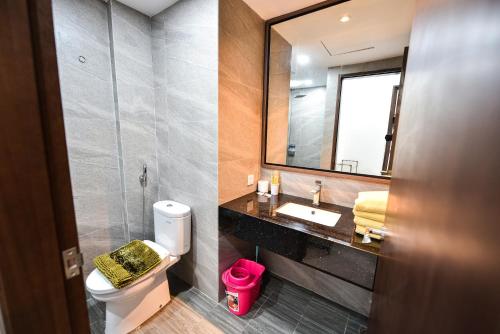 bagno con servizi igienici, lavandino e specchio di LOVINA 6-12 at Harbour Bay Residences a Nagoya