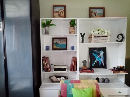 a white book shelf with pictures on it at maisonette with garden in Perea