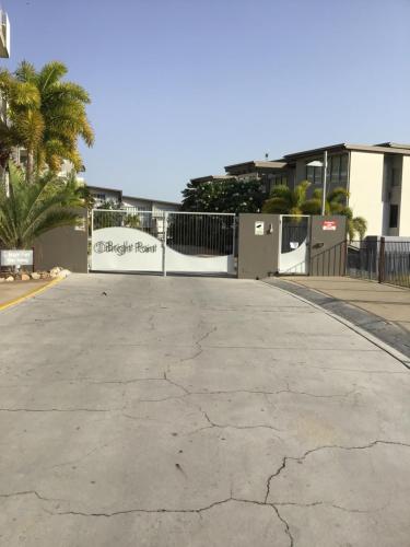 an empty parking lot with a fence and palm trees at 1213/146 Sooning street, Nelly Bay, Magnetic Island. Qld 4819. One Bright Point. in Nelly Bay