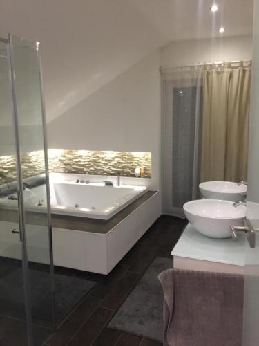 a bathroom with a tub and a toilet and a sink at HausGregor, Messe 15 min, City 20 min und Erholung im Grünen in Winkelhaid