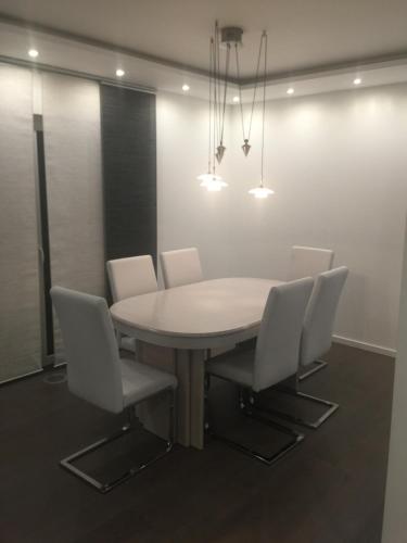a dining room with a white table and chairs at HausGregor, Messe 15 min, City 20 min und Erholung im Grünen in Winkelhaid