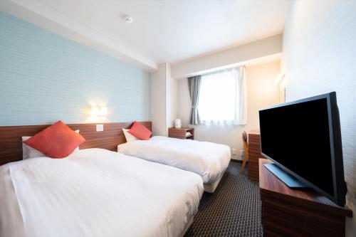 Habitación de hotel con 2 camas y TV de pantalla plana. en Pearl Hotel Ryogoku, en Tokio