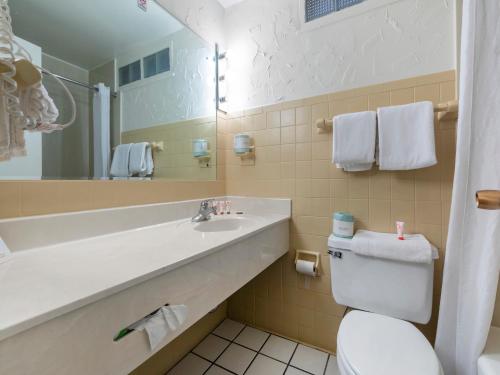 a bathroom with a sink and a toilet and a mirror at Mansion View Inn & Suites in Springfield