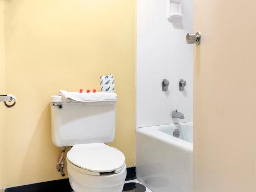 a bathroom with a white toilet and a bath tub at Mansion View Inn & Suites in Springfield