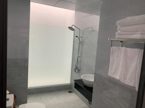 uma casa de banho com chuveiro, WC e toalhas em Hotel Hiệp Thành em Tuy Hoa