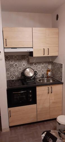 une cuisine avec une cuisinière et un évier dans l'établissement Studio Garrigues Gréoux les bains curistes Thalatherme, à Gréoux-les-Bains