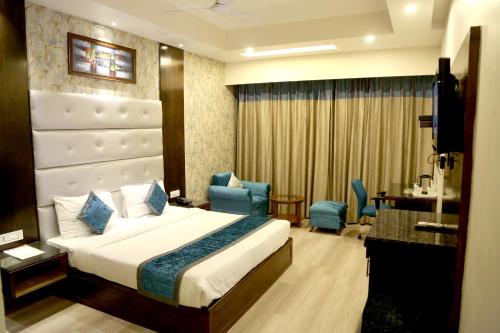 a hotel room with a bed and a desk and chairs at Hotel Shagun Chandigarh Zirakpur in Chandīgarh