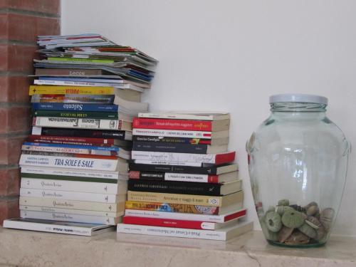 a stack of books sitting next to a vase at Casa Solento in Maruggio