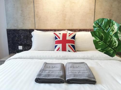 a bed with two towels and a pillow with a british flag at I City Residence, 2 Bedroom 4-6 Pax unit, Walking to Theme n Water Park & Shopping Mall in Shah Alam