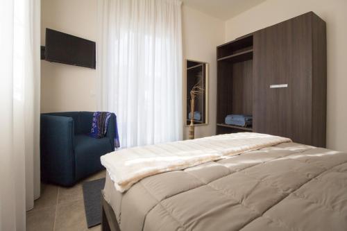 1 dormitorio con 1 cama y 1 silla azul en Casa di Sara en Zafferana Etnea