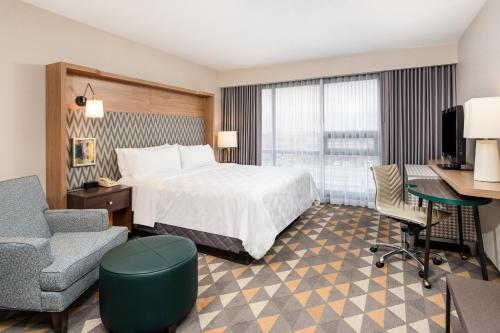 Cette chambre comprend un lit, un bureau et une chaise. dans l'établissement Holiday Inn Toronto Airport East, an IHG Hotel, à Toronto