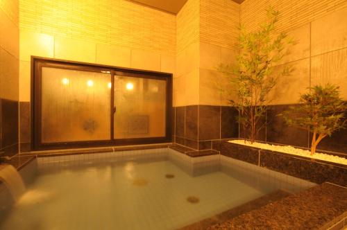 宇部にあるAB Hotel Ubeshinkawaのバスルーム(木のある大きなバスタブ付)