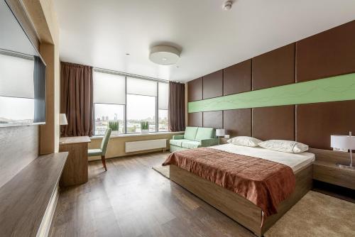 a hotel room with a bed and a chair and window at RADIUS Central House in Yekaterinburg