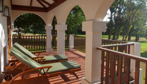 two lounge chairs on a porch with a fence at Sanctum Inle Resort in Nyaung Shwe