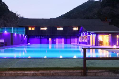 a house with a swimming pool at night at Amis Droles in Kawazu