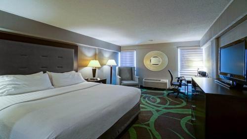 a hotel room with a large bed and a flat screen tv at Holiday Inn At the Campus, an IHG Hotel in Manhattan