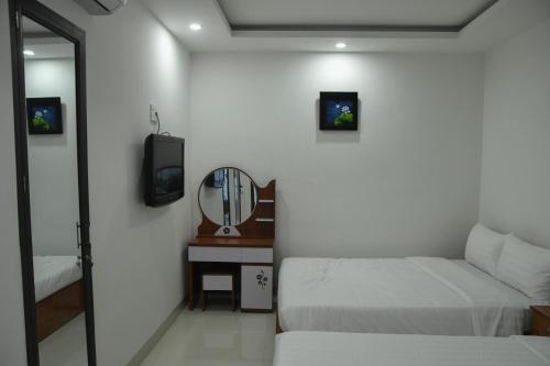 a small bedroom with two beds and a mirror at Asean Garden Homestay Hue in Hue