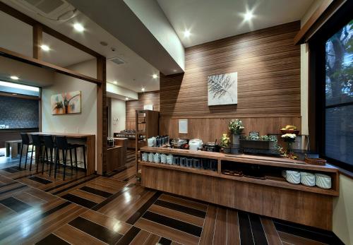 a kitchen with wooden walls and a counter with a bar at HOTEL ROUTE-INN Kamiyamada Onsen in Chikuma