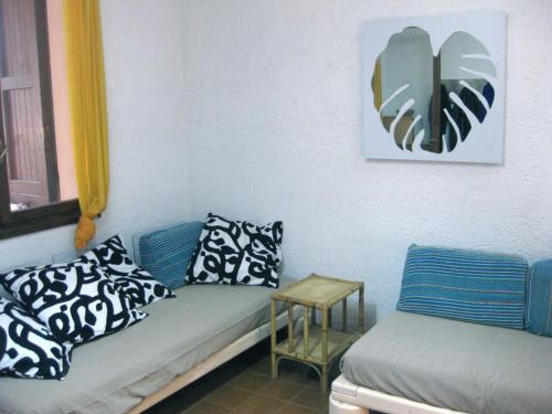 een woonkamer met een blauwe bank en een tafel bij Casa Baia in Capo Testa