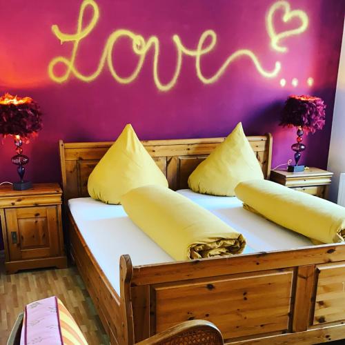 a bedroom with a bed with the word love written on the wall at Hotel Restaurant Rössle in Calw
