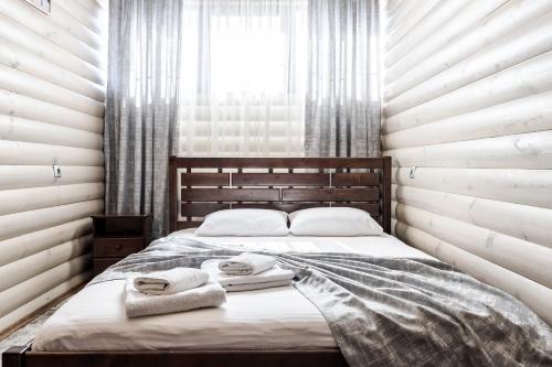 a bedroom with a bed with towels on it at Маєток "ZYMON & SKI" in Bukovel