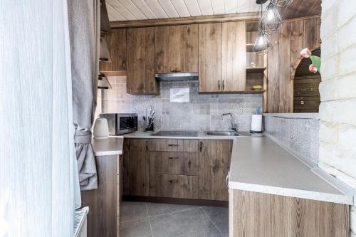 a kitchen with wooden cabinets and a sink at Маєток "ZYMON & SKI" in Bukovel