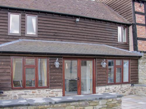 a house with glass doors on the side of it at Alders View Coach House in Craven Arms