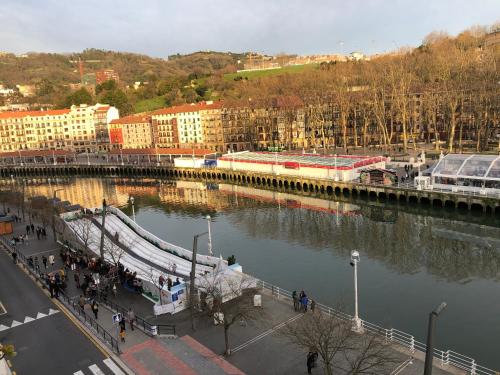 a bridge over a river next to a city at Hotel Ripa in Bilbao