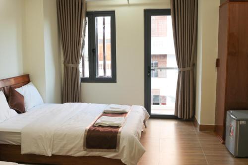 een slaapkamer met een bed en twee ramen bij Khách sạn Trường Long in Phan Rang