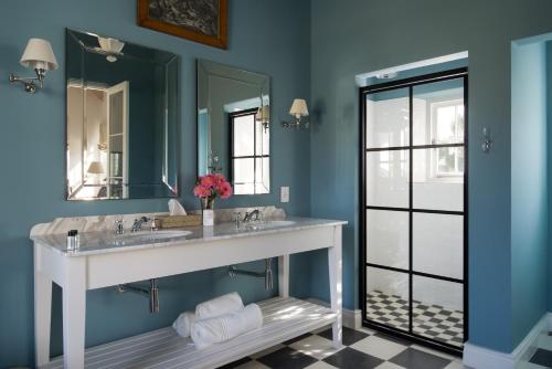 a bathroom with two sinks and a large mirror at La Cotte Orchard Cottages in Franschhoek